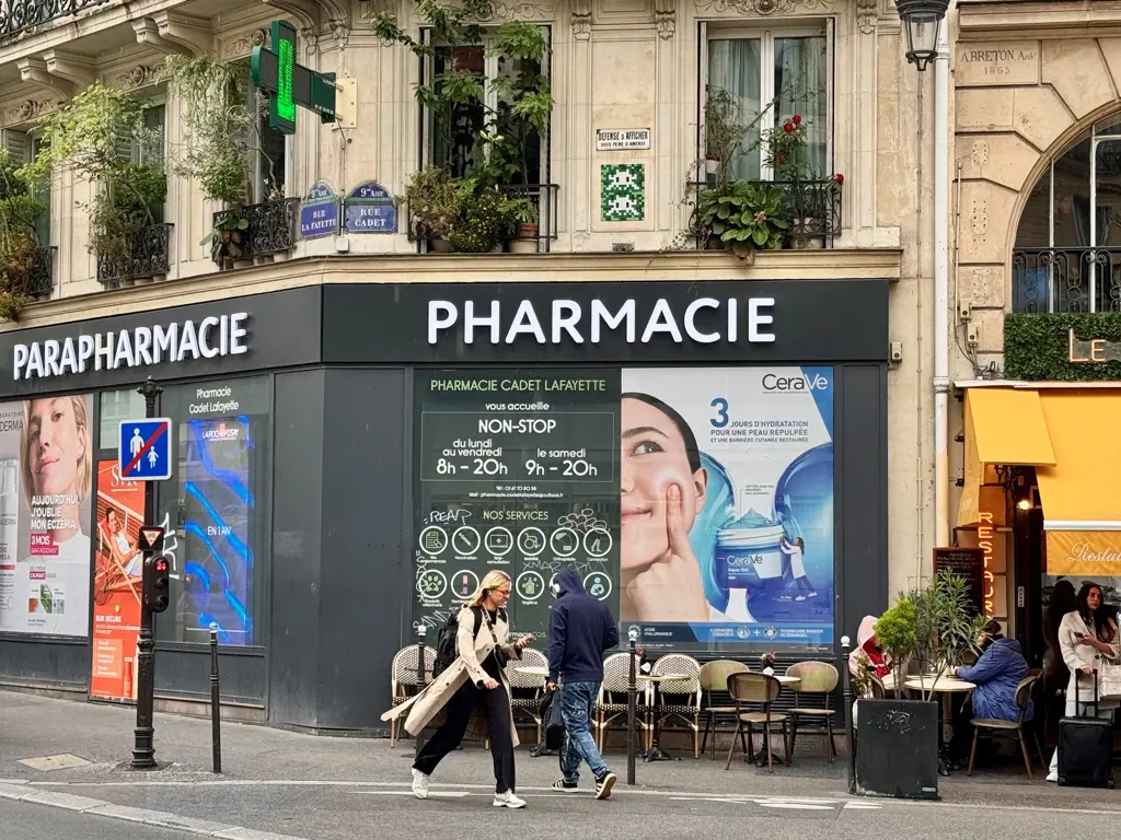 Au-dessus d’une pharmacie, un œuvre d’invader représentant deux Space Invaders tout en nuances de verts.